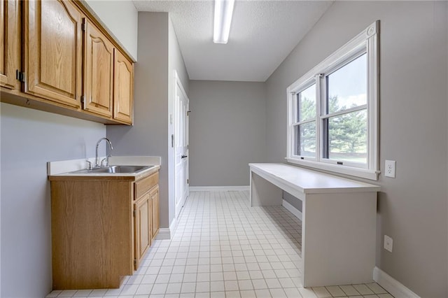 12815 NW 145th St, Platte City, MO 64079 - washroom with light tile patterned flooring, baseboards, a sink, and a textured ceiling