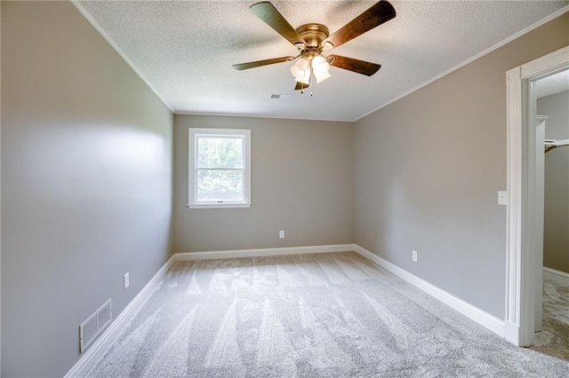 carpeted empty room with a textured ceiling, ceiling fan, and crown molding