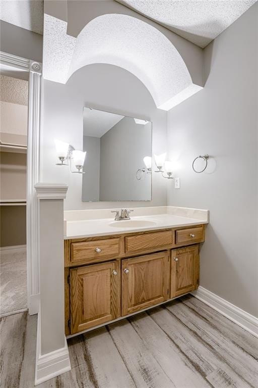 bathroom featuring hardwood / wood-style floors, vanity, and a textured ceiling