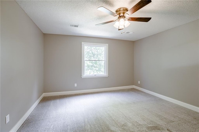 spare room with a textured ceiling, ceiling fan, and light carpet