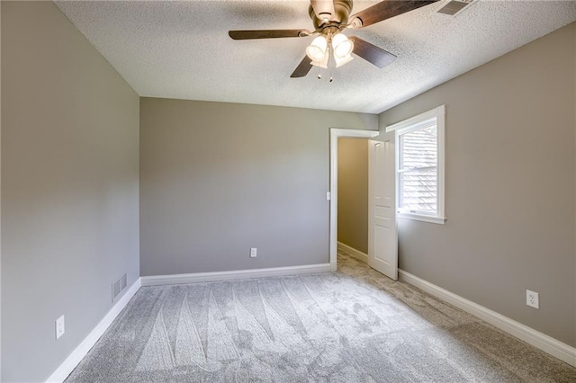 carpeted spare room with ceiling fan and a textured ceiling