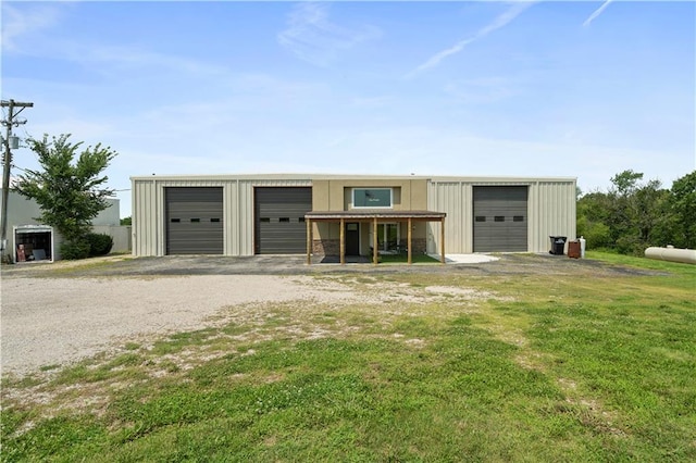 view of front of property with covered porch, a garage, and a front lawn