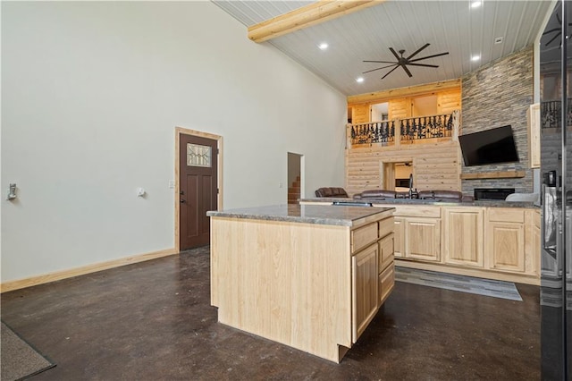 kitchen featuring light brown cabinets, a kitchen island, beam ceiling, high vaulted ceiling, and ceiling fan