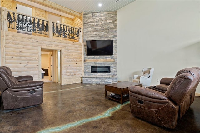 living room featuring a stone fireplace and concrete flooring