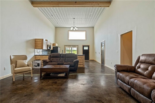 living room with beamed ceiling, a notable chandelier, and a high ceiling