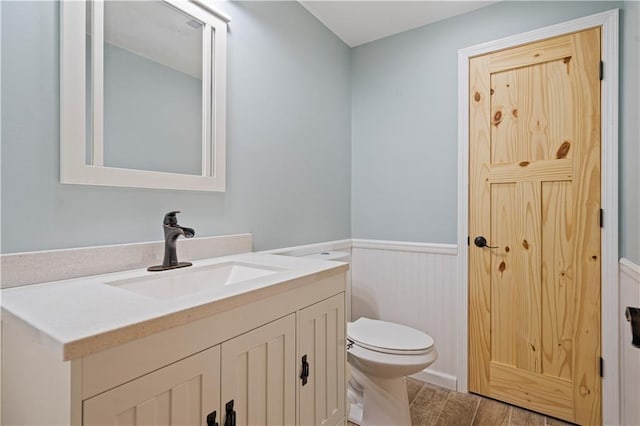 bathroom featuring vanity, wood-type flooring, and toilet