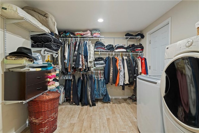 spacious closet featuring washer / dryer and light hardwood / wood-style flooring