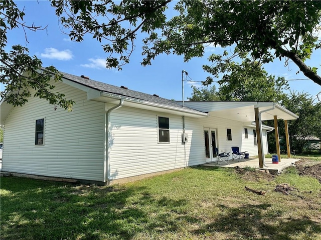 rear view of house with a patio and a yard