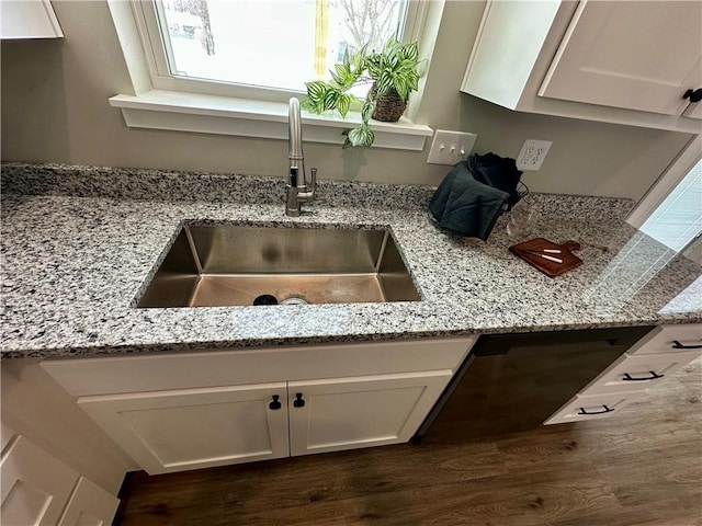 details featuring dark hardwood / wood-style flooring, light stone countertops, sink, and white cabinets