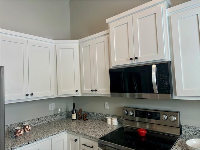 kitchen featuring light stone countertops, appliances with stainless steel finishes, and white cabinets