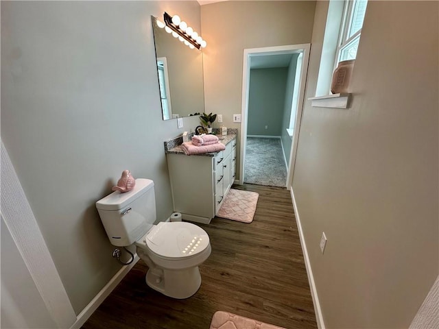 bathroom with wood-type flooring, toilet, and vanity