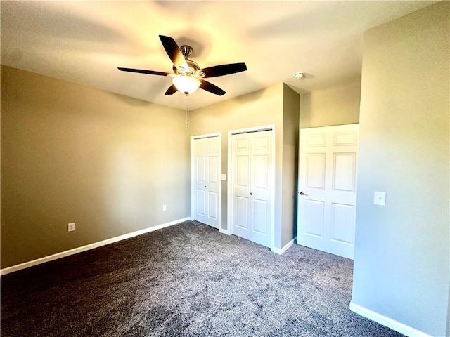 unfurnished bedroom featuring two closets, ceiling fan, and carpet flooring