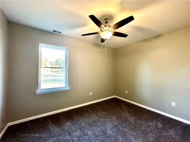 spare room with ceiling fan and carpet