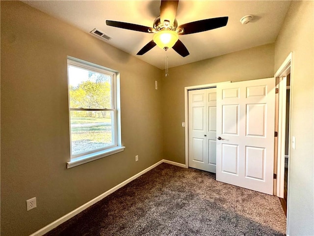 unfurnished bedroom with ceiling fan, carpet flooring, and a closet