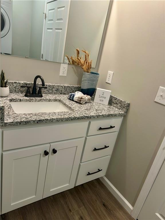 bathroom featuring hardwood / wood-style flooring, vanity, and washer / dryer