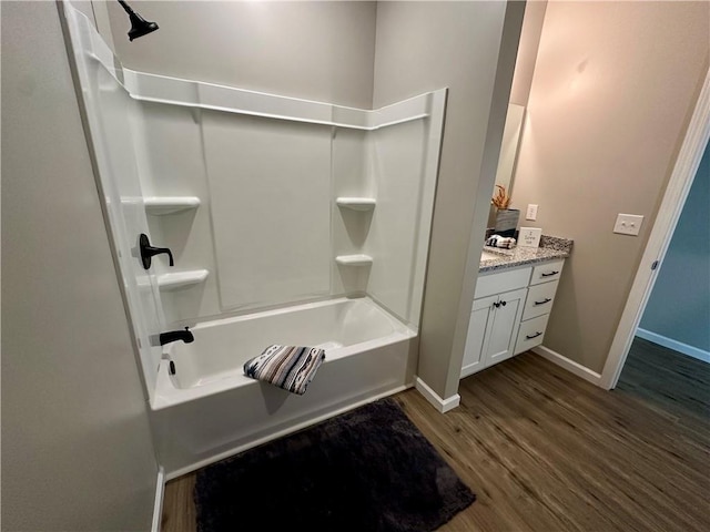 bathroom featuring hardwood / wood-style flooring, vanity, and bathtub / shower combination