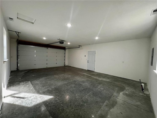 garage with a garage door opener and electric panel