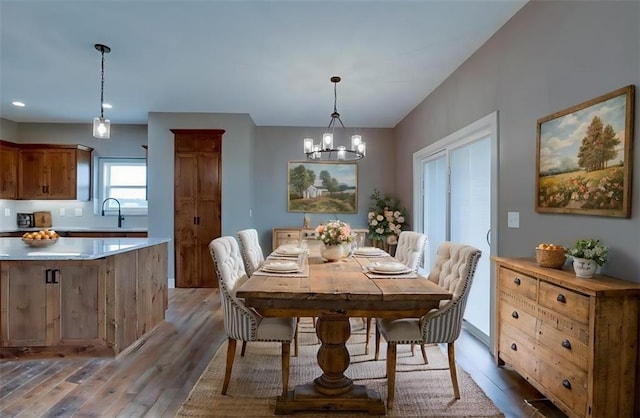 dining room with a chandelier, light hardwood / wood-style flooring, and sink