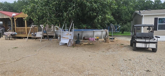 view of yard featuring a swimming pool side deck and a trampoline