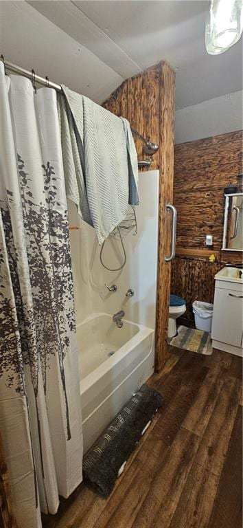 full bathroom featuring shower / bathtub combination with curtain, vaulted ceiling, toilet, vanity, and hardwood / wood-style flooring