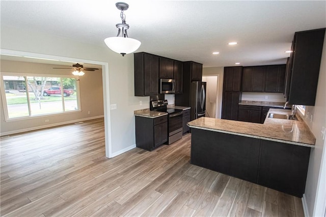 kitchen featuring stainless steel appliances, recessed lighting, a sink, and light wood-style flooring