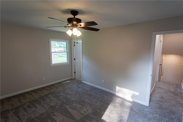 carpeted spare room with visible vents, baseboards, and a ceiling fan