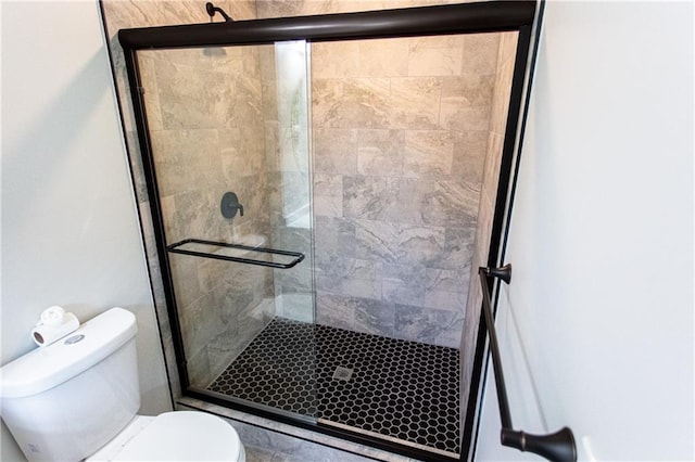 bathroom with toilet and a shower stall