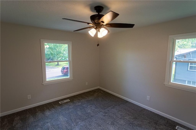 unfurnished room with baseboards, visible vents, and a healthy amount of sunlight