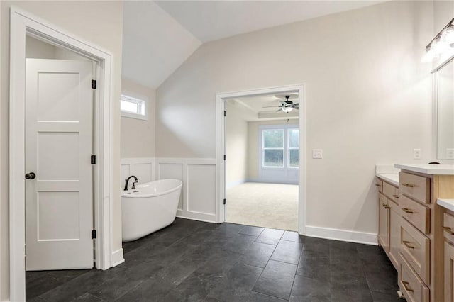 bathroom with vanity, a bathtub, vaulted ceiling, and ceiling fan