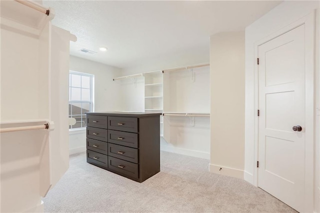 spacious closet featuring light colored carpet