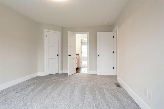 unfurnished bedroom with light colored carpet