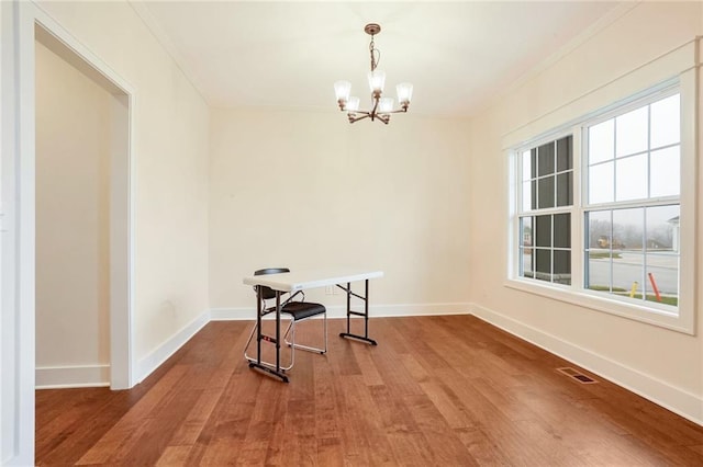 dining area with crown molding, a chandelier, and wood-type flooring