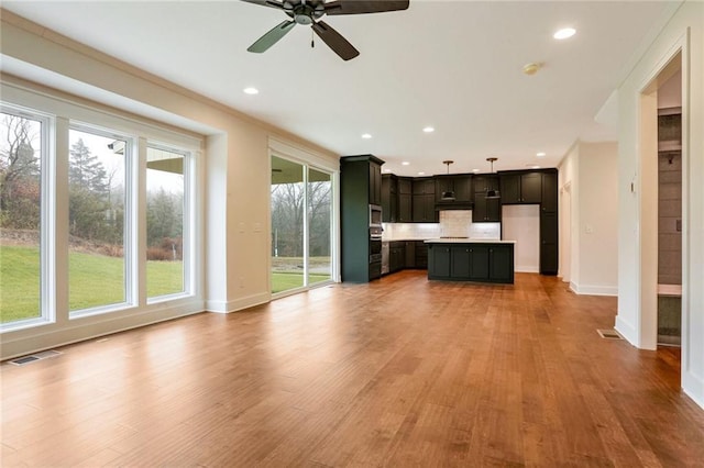 unfurnished living room with ceiling fan and light hardwood / wood-style floors