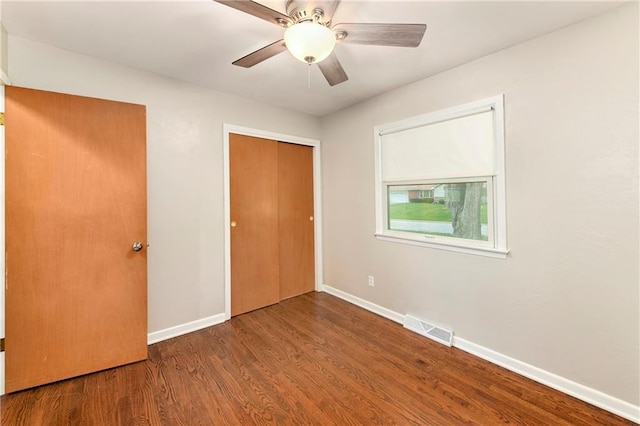 unfurnished bedroom featuring hardwood / wood-style floors, ceiling fan, and a closet