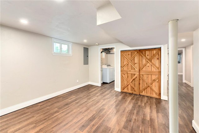 basement featuring electric panel, dark hardwood / wood-style flooring, and independent washer and dryer