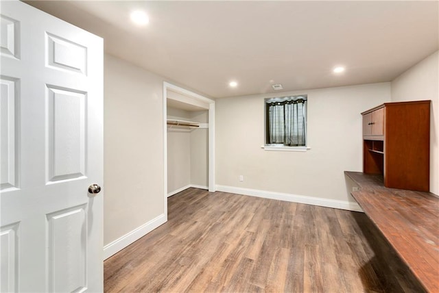 unfurnished bedroom featuring a closet and hardwood / wood-style floors