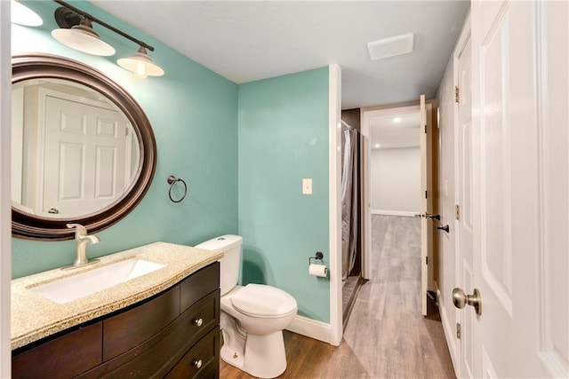 bathroom with curtained shower, wood-type flooring, vanity, and toilet