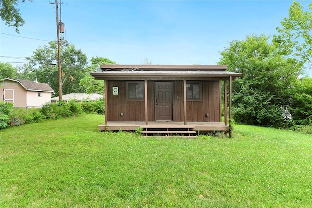 back of house with a storage shed and a yard