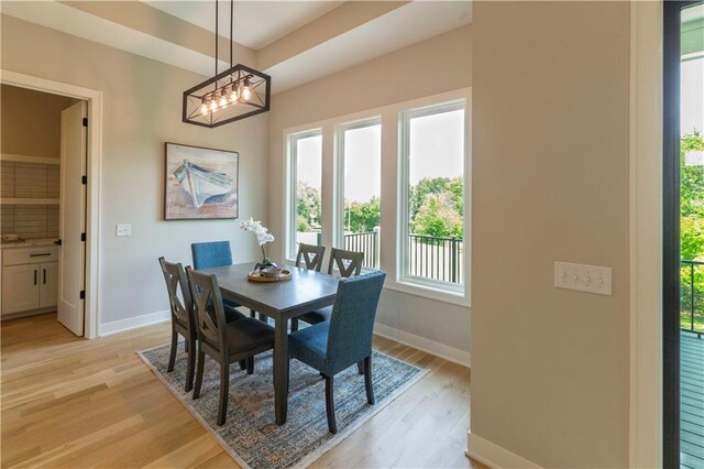 dining room with light wood-type flooring and an inviting chandelier