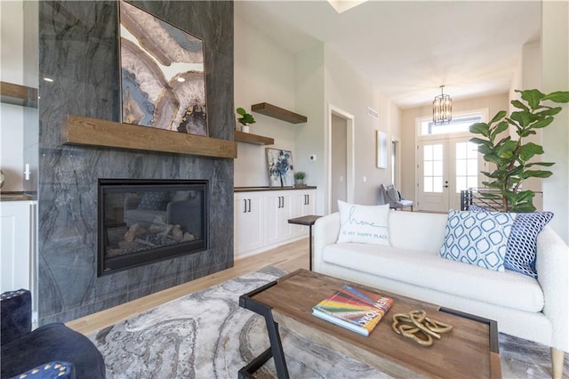 living room with a large fireplace and light hardwood / wood-style flooring