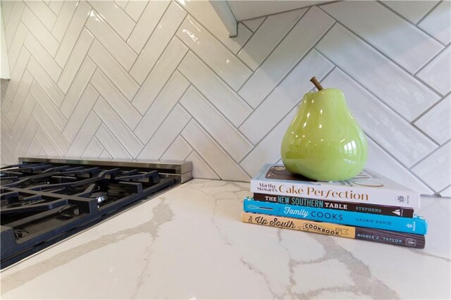 interior details with black gas cooktop and light stone counters