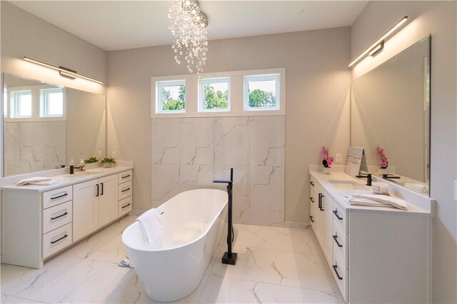 bathroom with plenty of natural light, a bath, vanity, and a chandelier