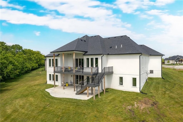 rear view of property with a lawn, a deck, and a patio