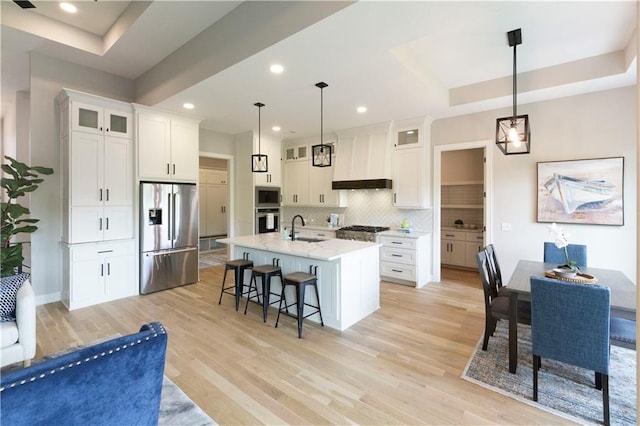 kitchen with appliances with stainless steel finishes, tasteful backsplash, sink, decorative light fixtures, and white cabinets