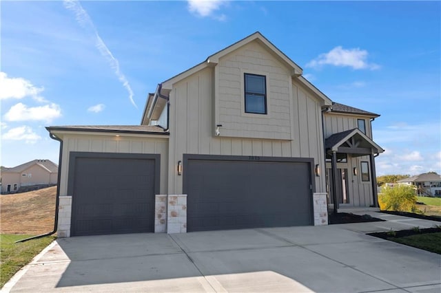 7075 NW Magnus Ct, Parkville, MO 64152 - modern inspired farmhouse with board and batten siding, driveway, stone siding, and an attached garage