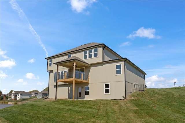 back of house with a yard and a balcony