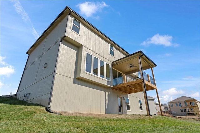 rear view of house featuring a yard and ceiling fan