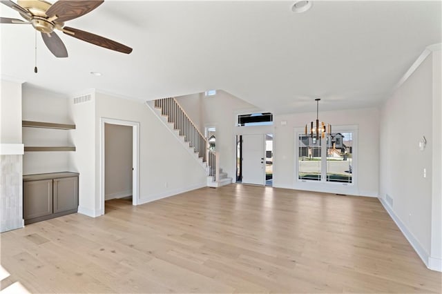 unfurnished living room featuring ceiling fan with notable chandelier and light wood-type flooring