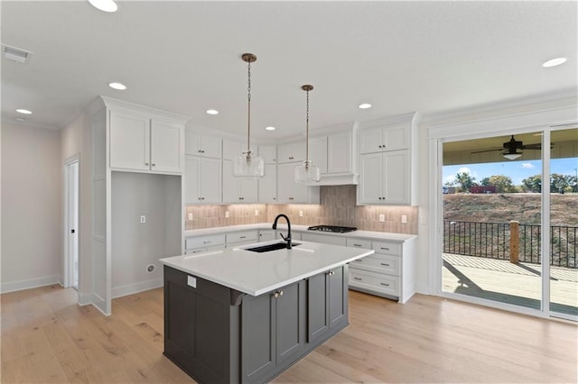 kitchen featuring light hardwood / wood-style flooring, an island with sink, and white cabinets