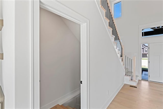 7075 NW Magnus Ct, Parkville, MO 64152 - entryway with stairway, wood finished floors, baseboards, and a towering ceiling